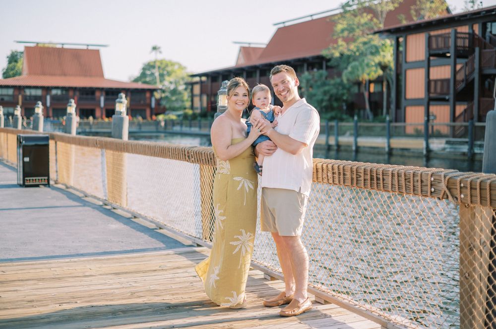 Family walks together on a brick paved path near buildings on a sunny day.