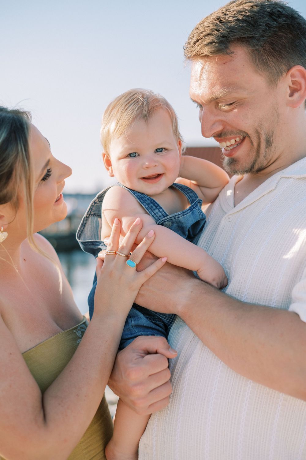 Tender family moment captured in soft lighting during a beach photo session.