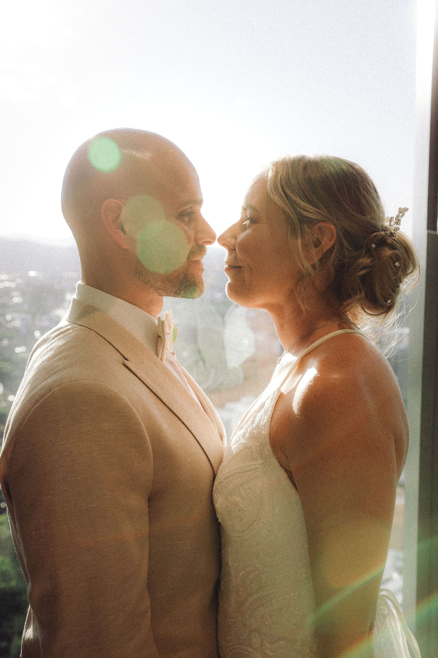 A reception toast moment captured at a beautiful bayside wedding venue surrounded by glass windows and natural light.