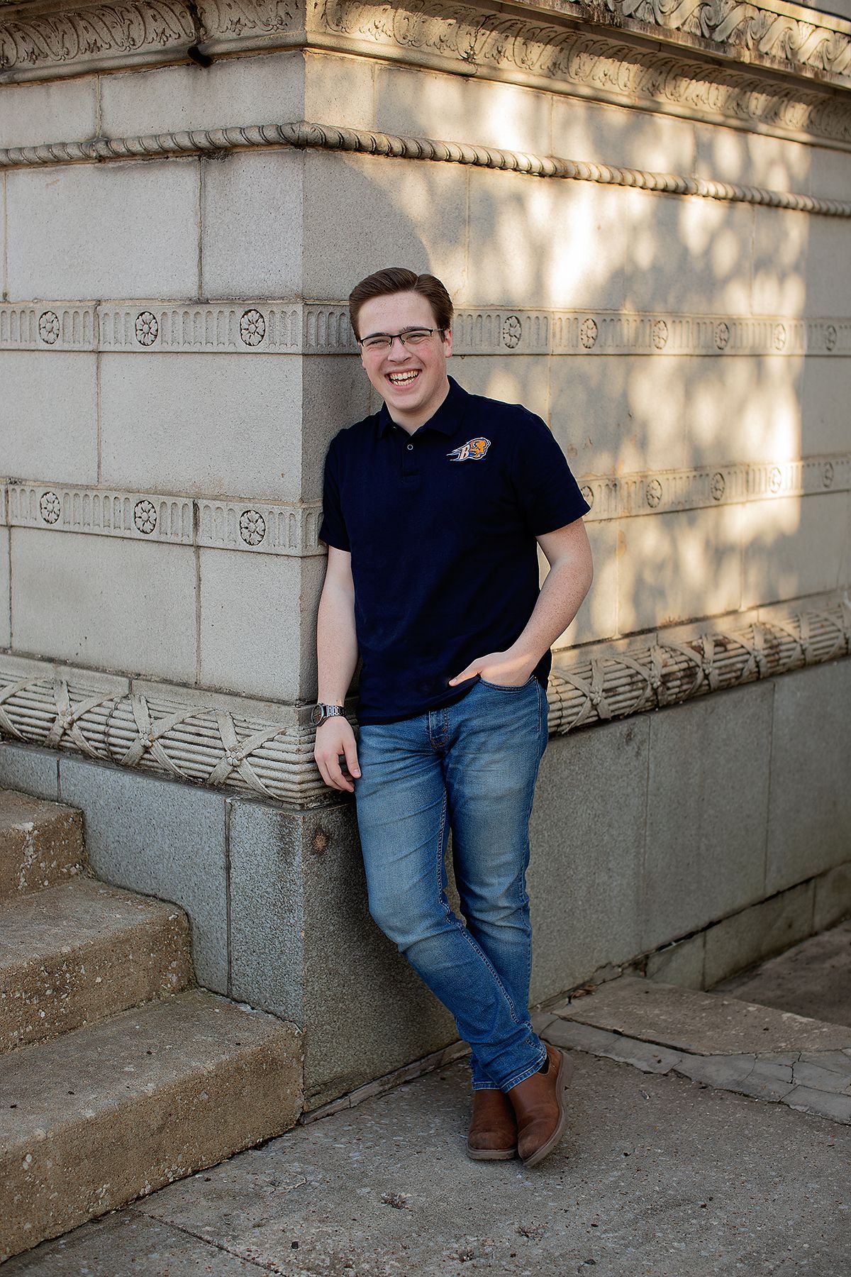 Senior pictures by MegMc Photography of a male teen wearing his college choice shirt in front of the Ned McWherter Theater in Jackson, TN.