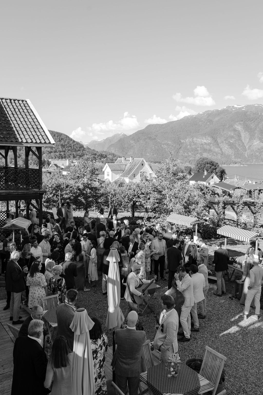 Black and white photo of wedding guests gathered at an outdoor mountain venue.