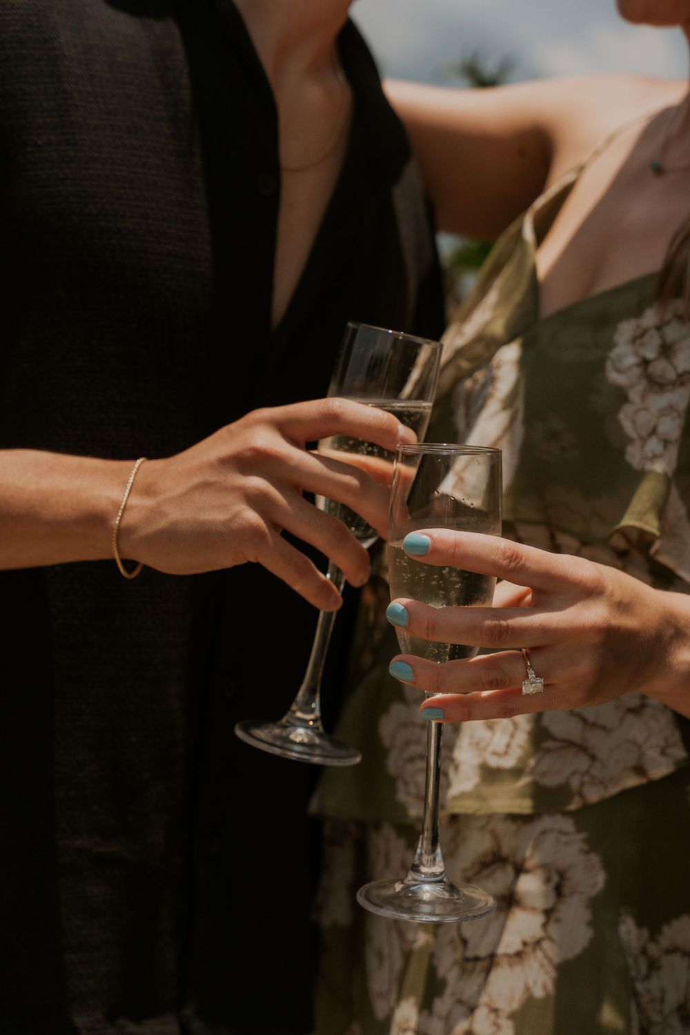Two people toasting with champagne glasses during a celebration while wearing elegant attire.