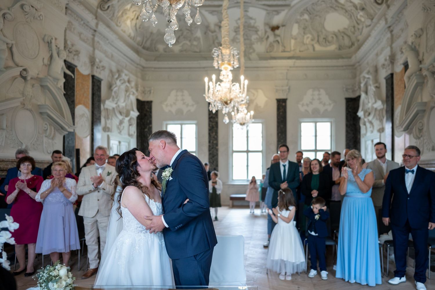 Brautpaar küsst sich im Saal, Familie schaut zu, emotionale Szene, Schloss Mirow