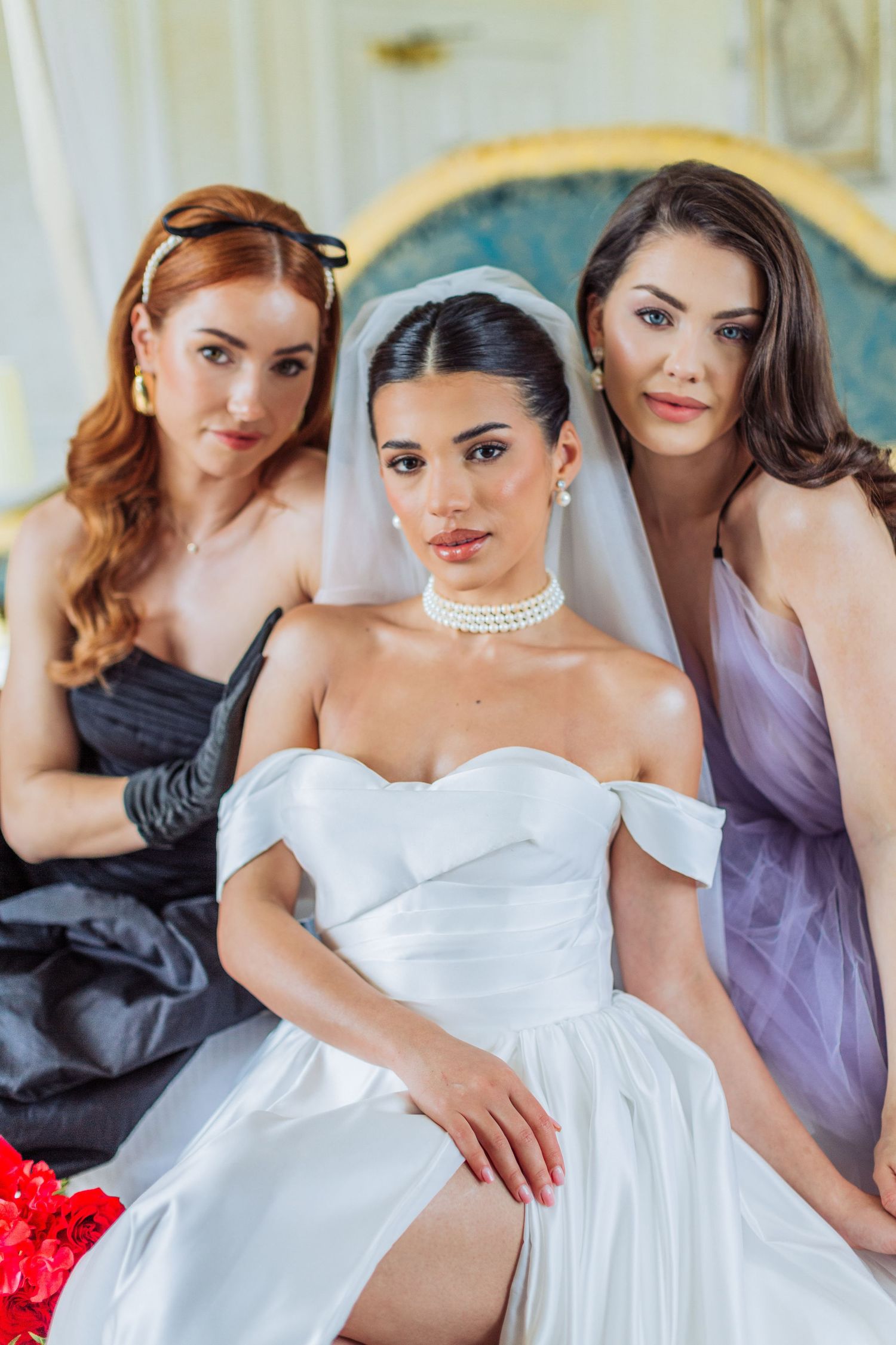 Bride and bridesmaids pose elegantly in dresses, with the bride in a white off-shoulder gown and pearl choker at Hedsor House Buckingham