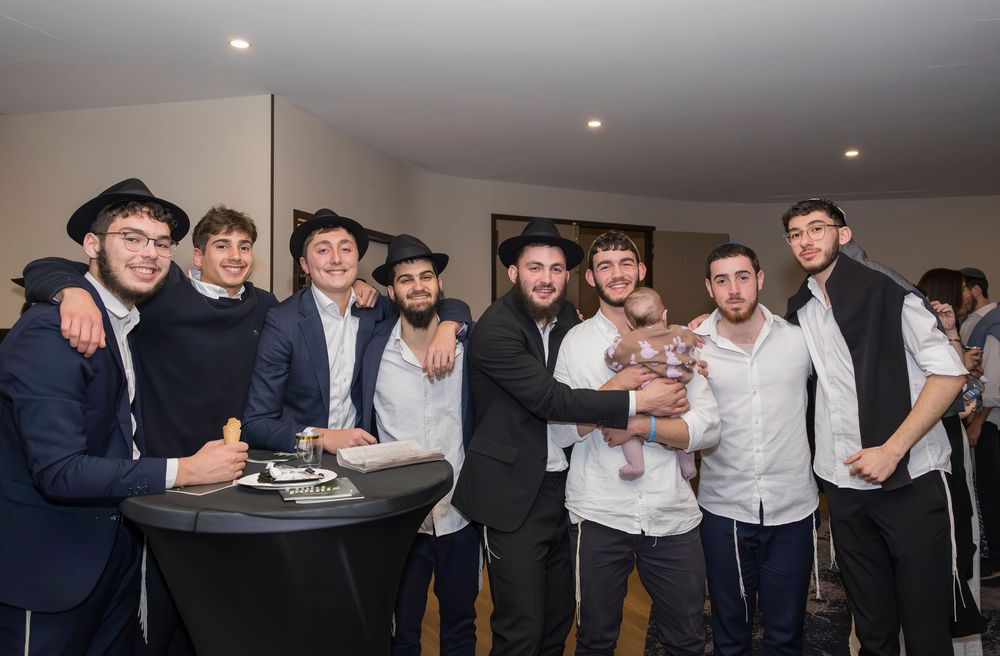 A series of party guests in formal attire dance and celebrate at a social gathering in a brightly lit room.