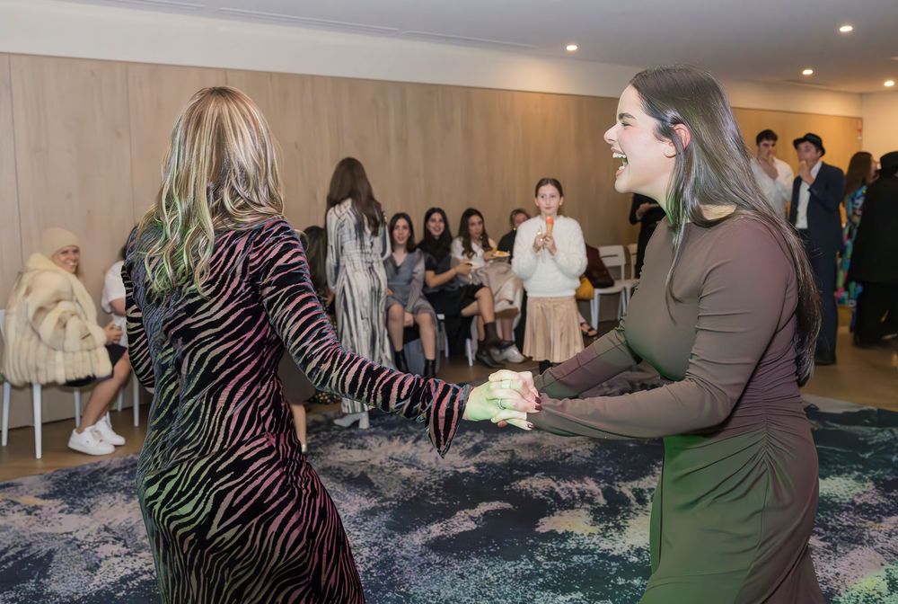Multiple dance workshop participants learn salsa moves in a carpeted hotel conference room.