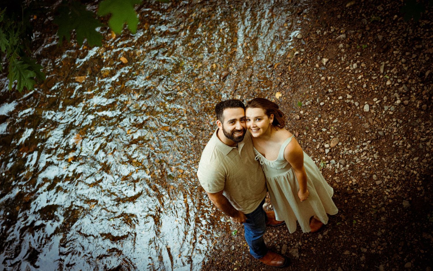 A couple shares a romantic aerial view moment against a textured stone wall background.