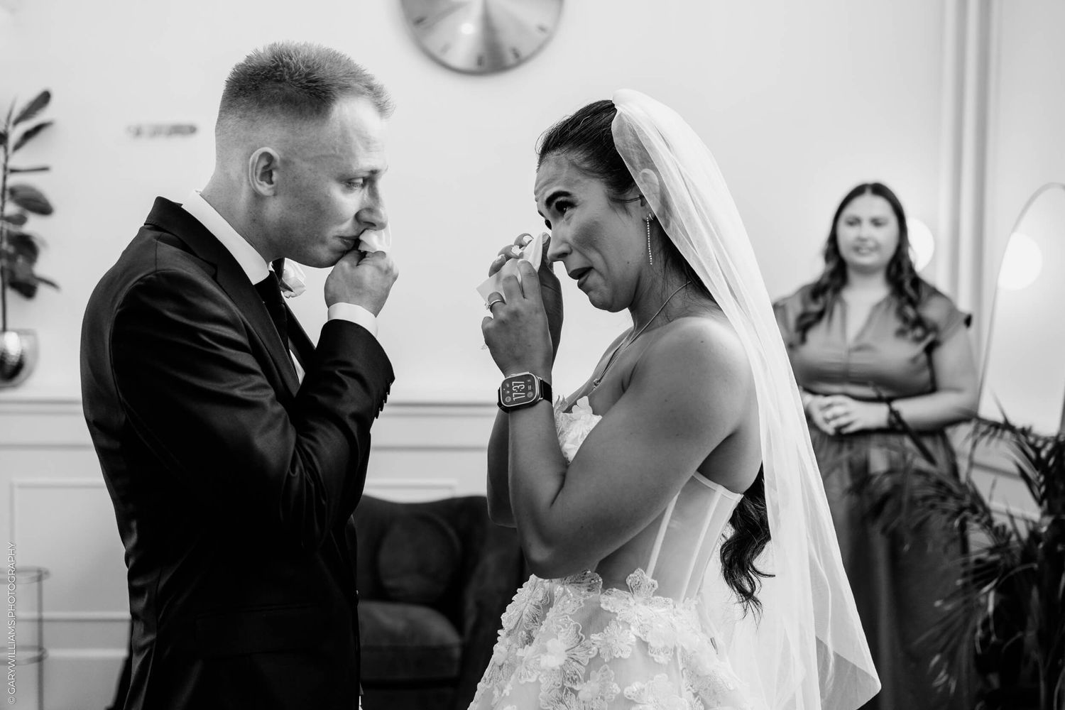 Emotional moment captured in black and white at an indoor wedding ceremony with two people in formal attire.