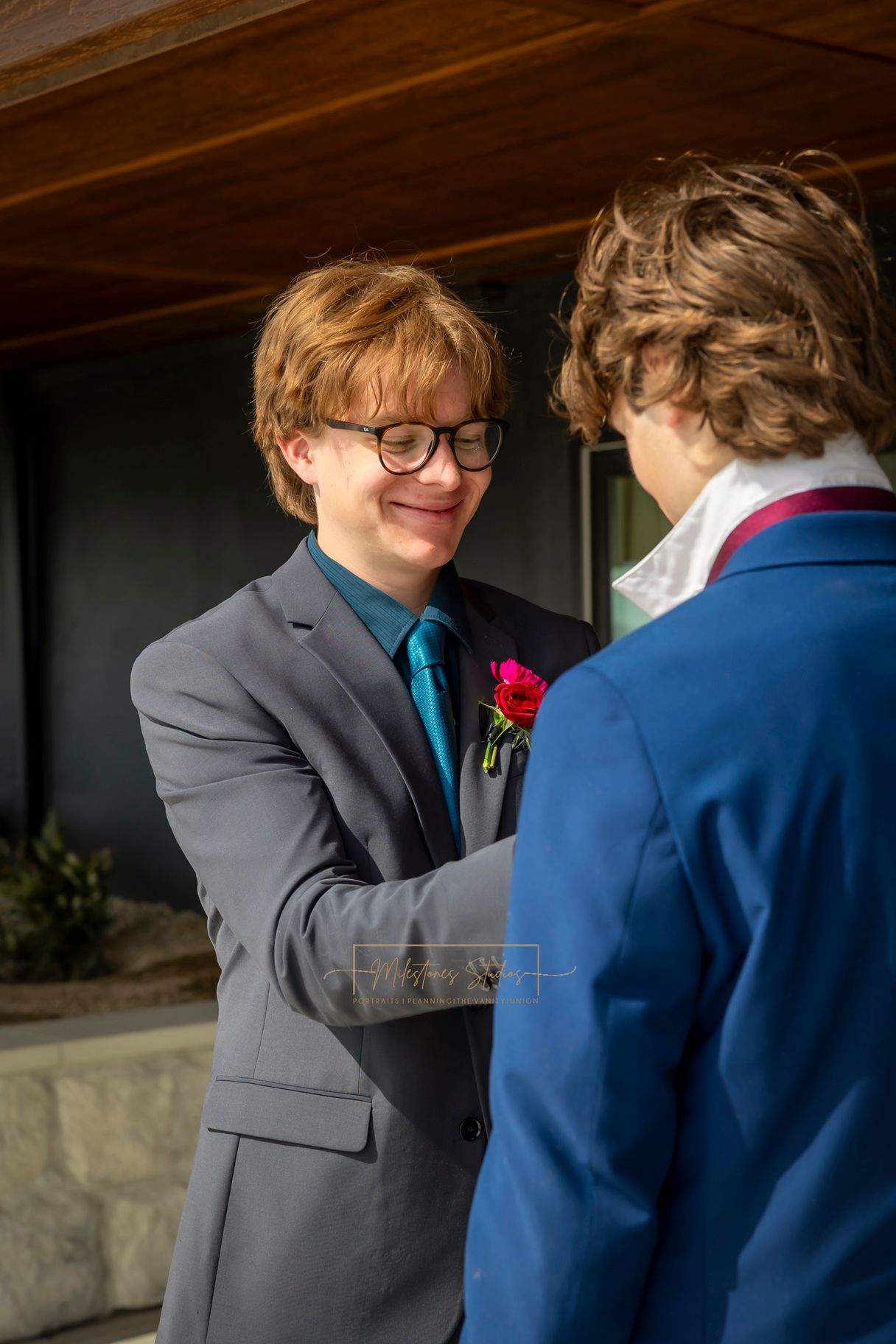groom fixing tie on groomsman
