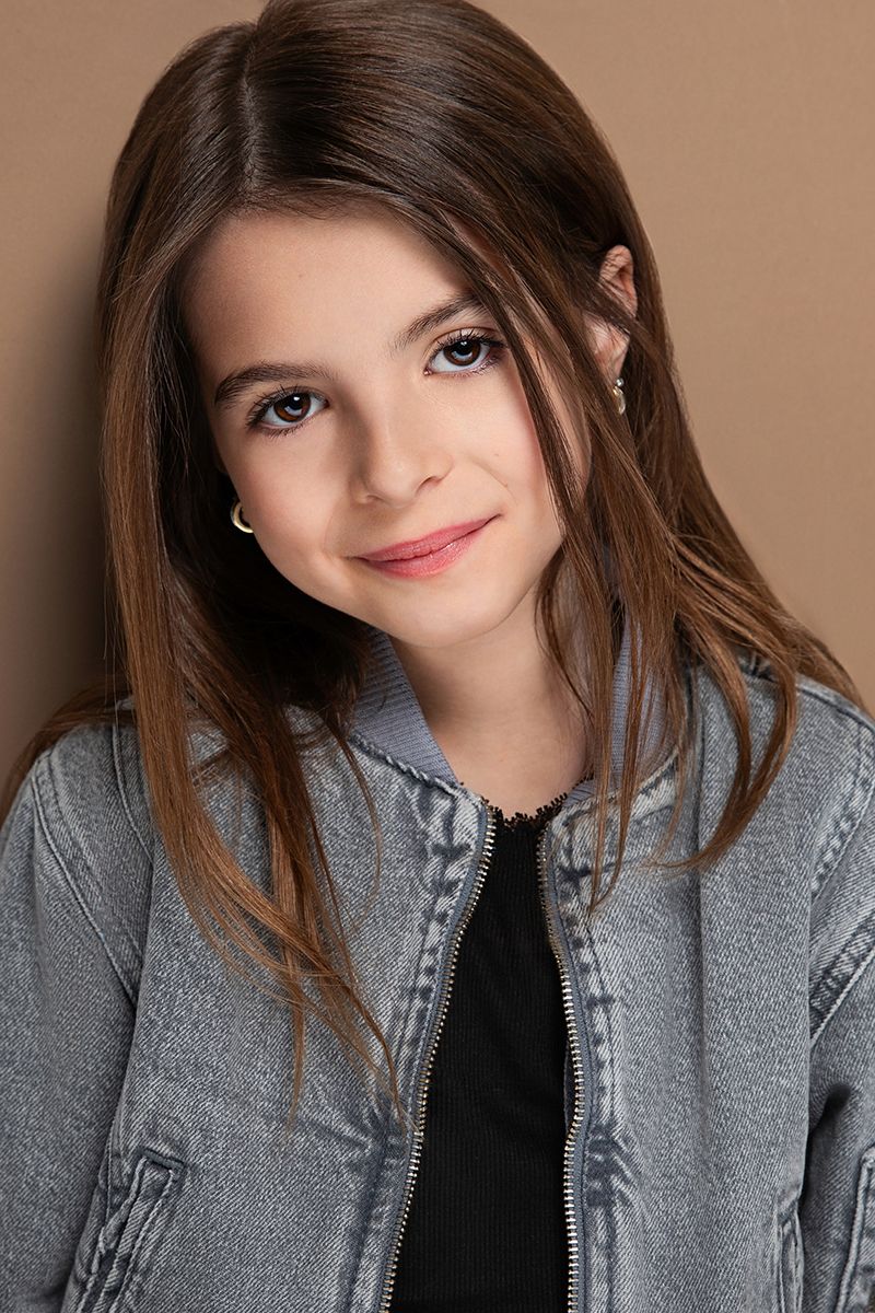 Young model in blue and white checkered button-down shirt against bright blue background.