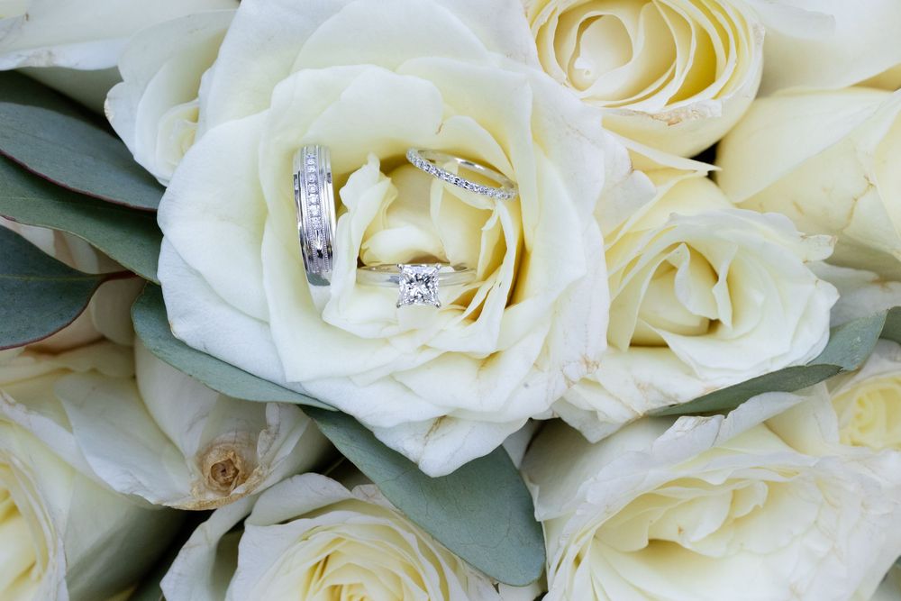 Close-up details of creamy white roses with diamond rings nestled among the petals.