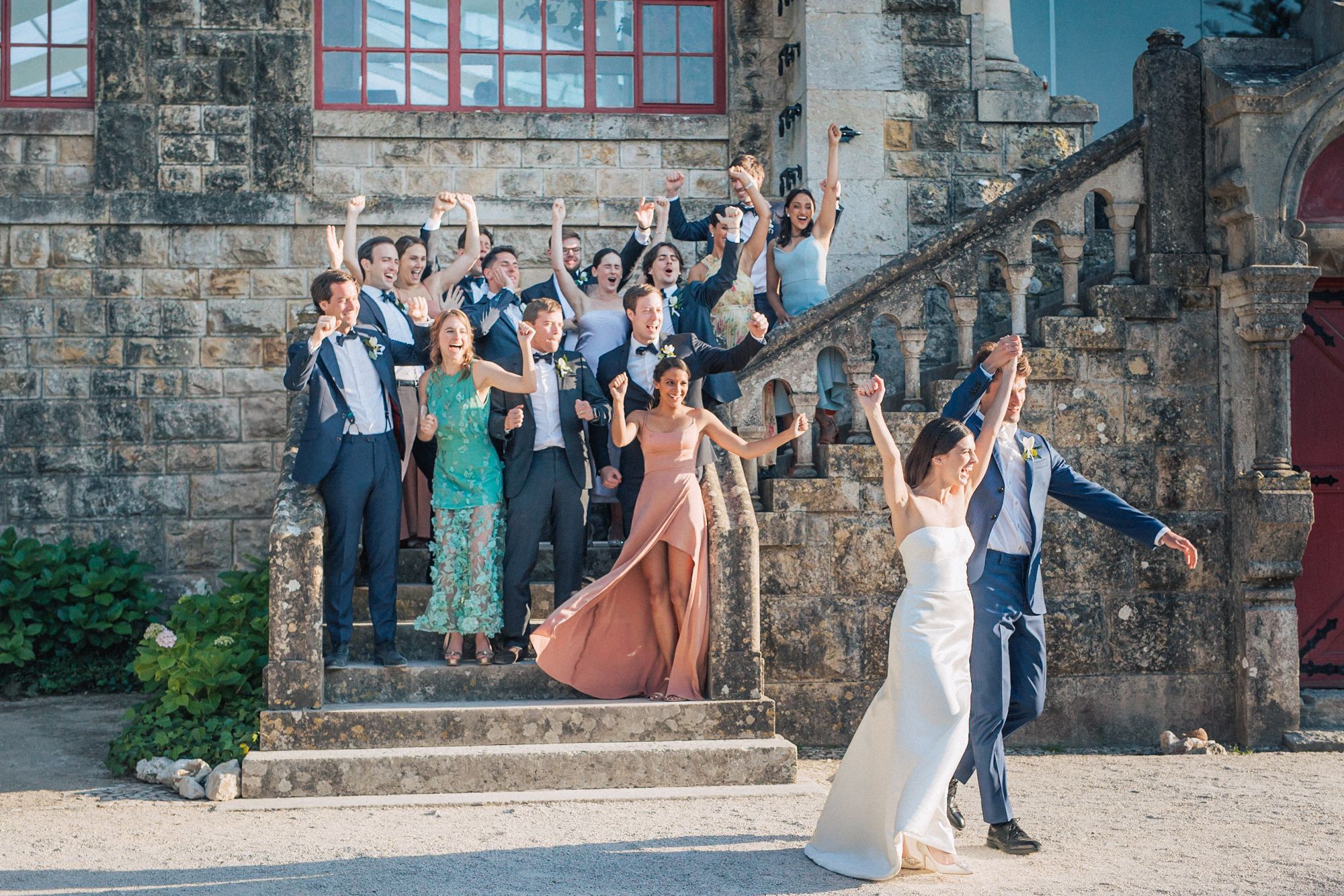 Wedding party celebrating outside historic Forte da Cruz. captured by a Portugal destination wedding photographer