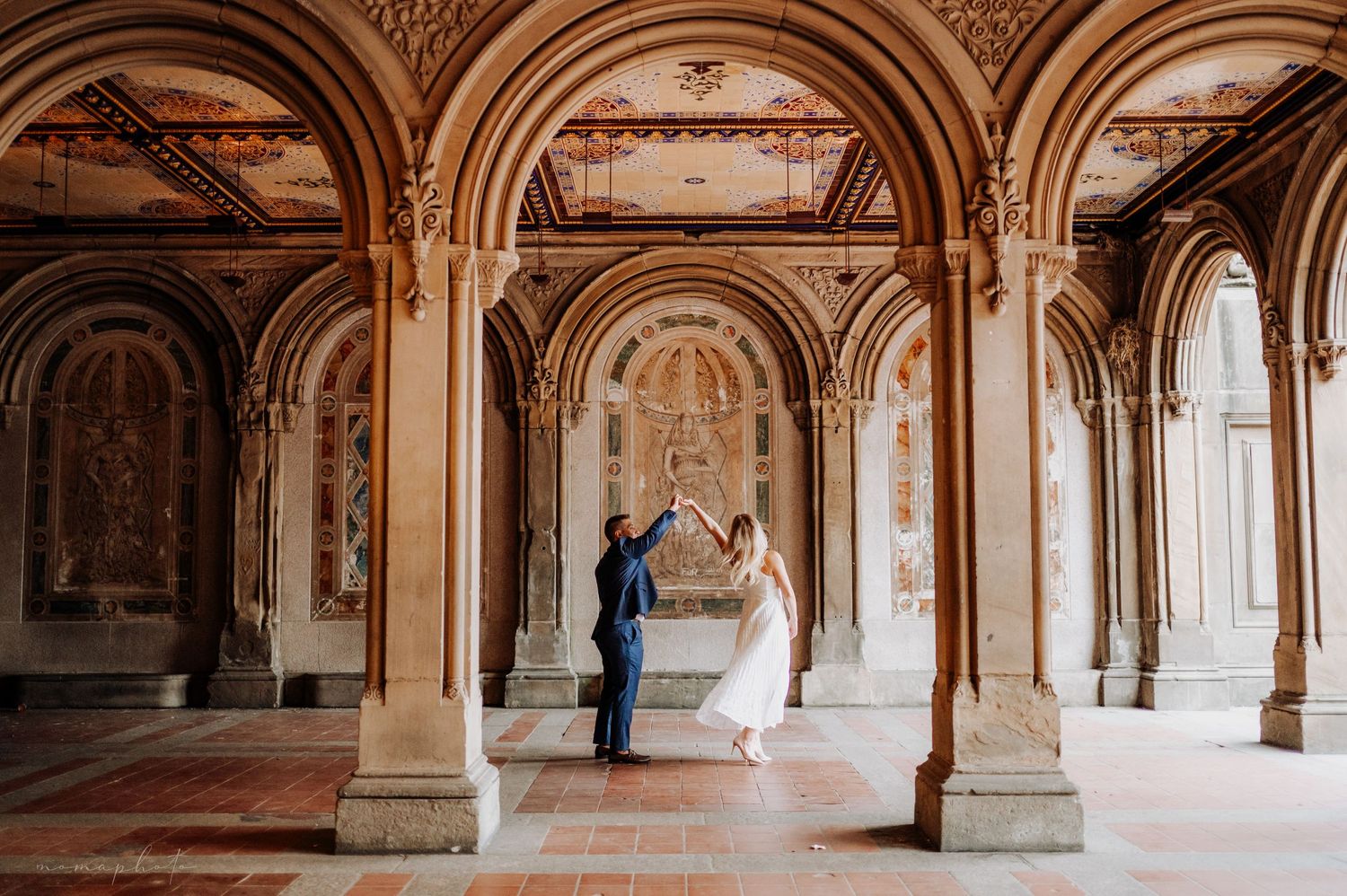 A romantic wedding portrait in a grand historic building with arched columns and ornate architecture.