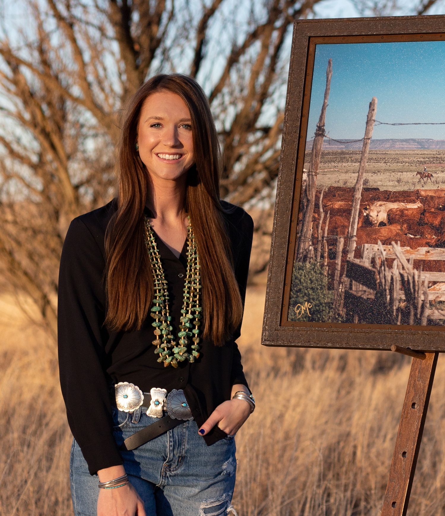Emily McCartney Eiguren with a framed copy of Between Here & the Mesa