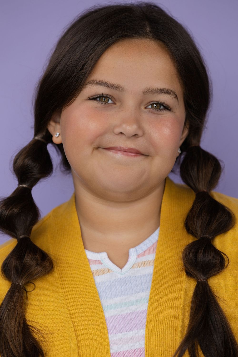 A series of headshots with pigtails wearing a bright yellow cardigan and white top on purple background.