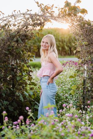 A summer garden portrait with blooming flowers and a natural archway.