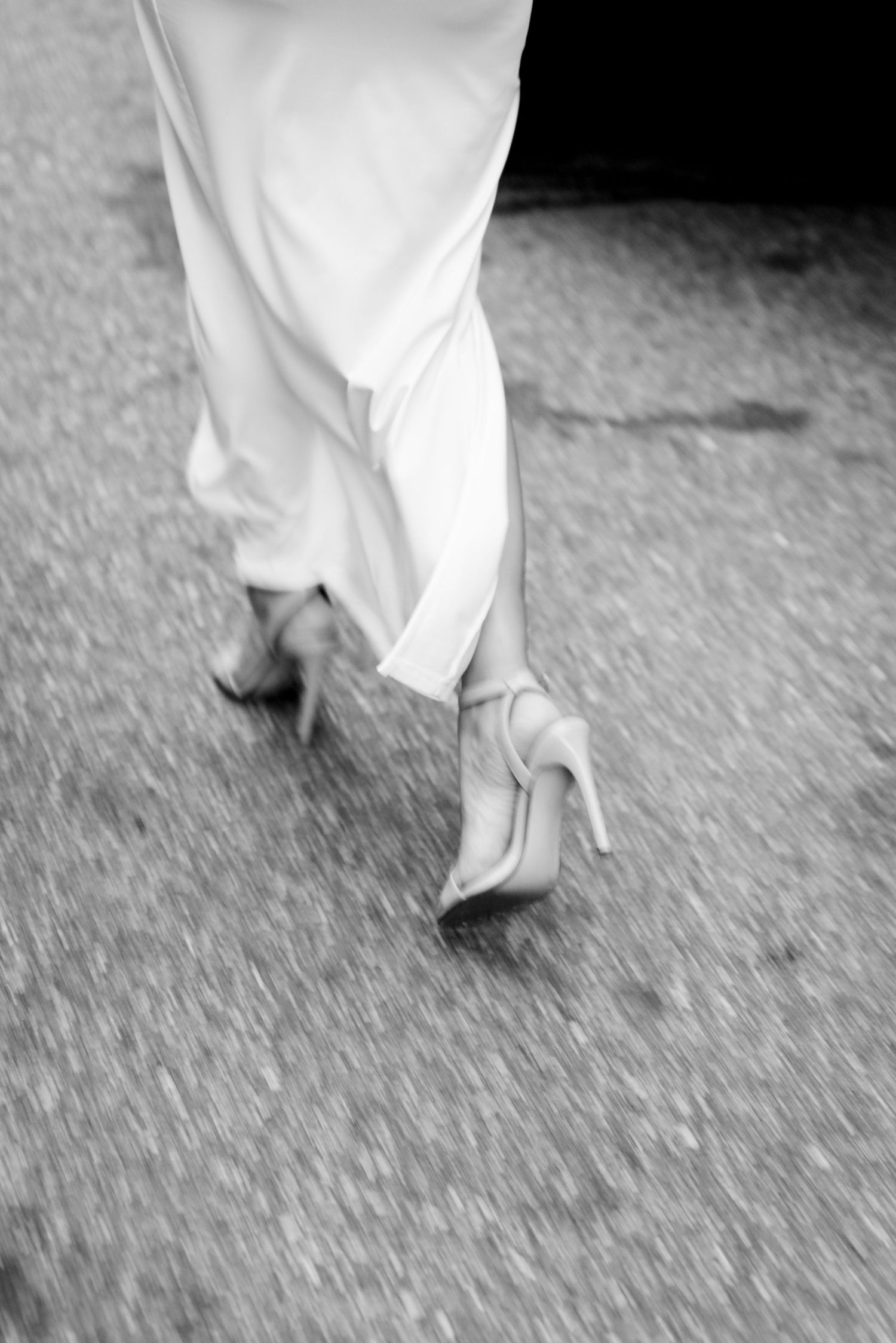 woman in nude heels running through streets in NYC for engagement photos in flatiron district