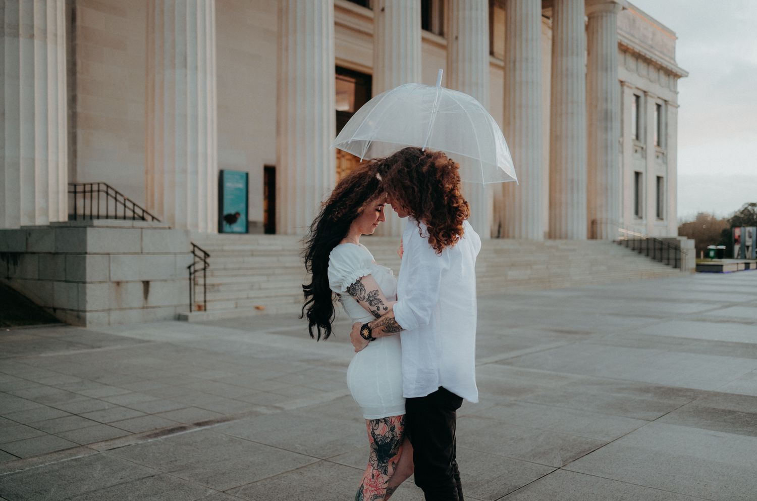 Couple with an umbrella on their engagement shoot in Auckland Museum with Apertured Media-Auckland Wedding Photographer