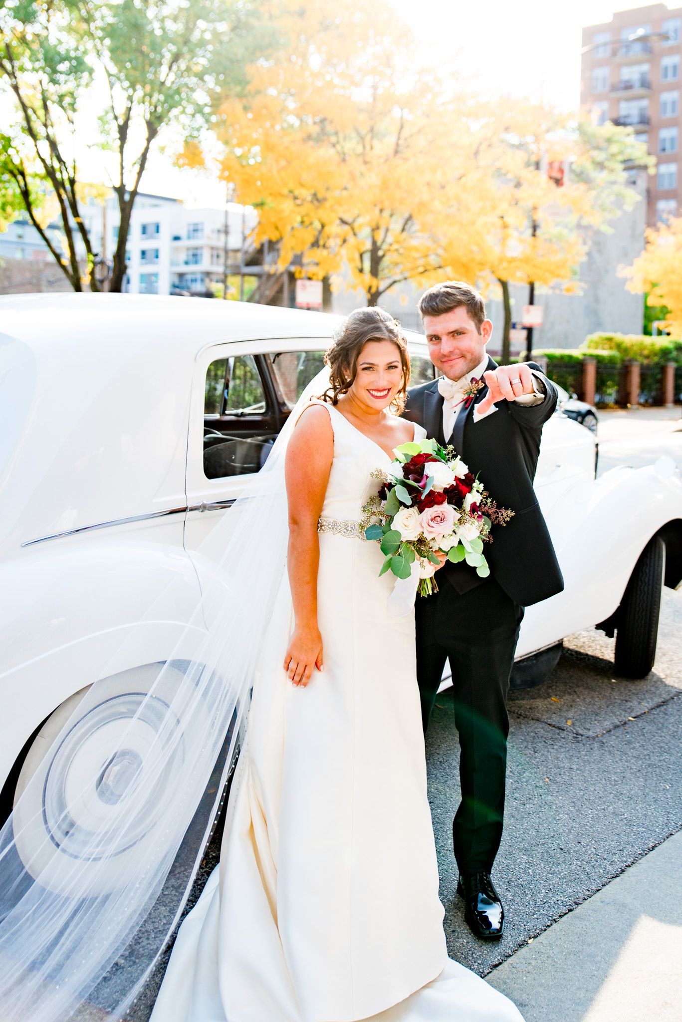 newlyweds smile with colorful flower bouquet in chicago streets
