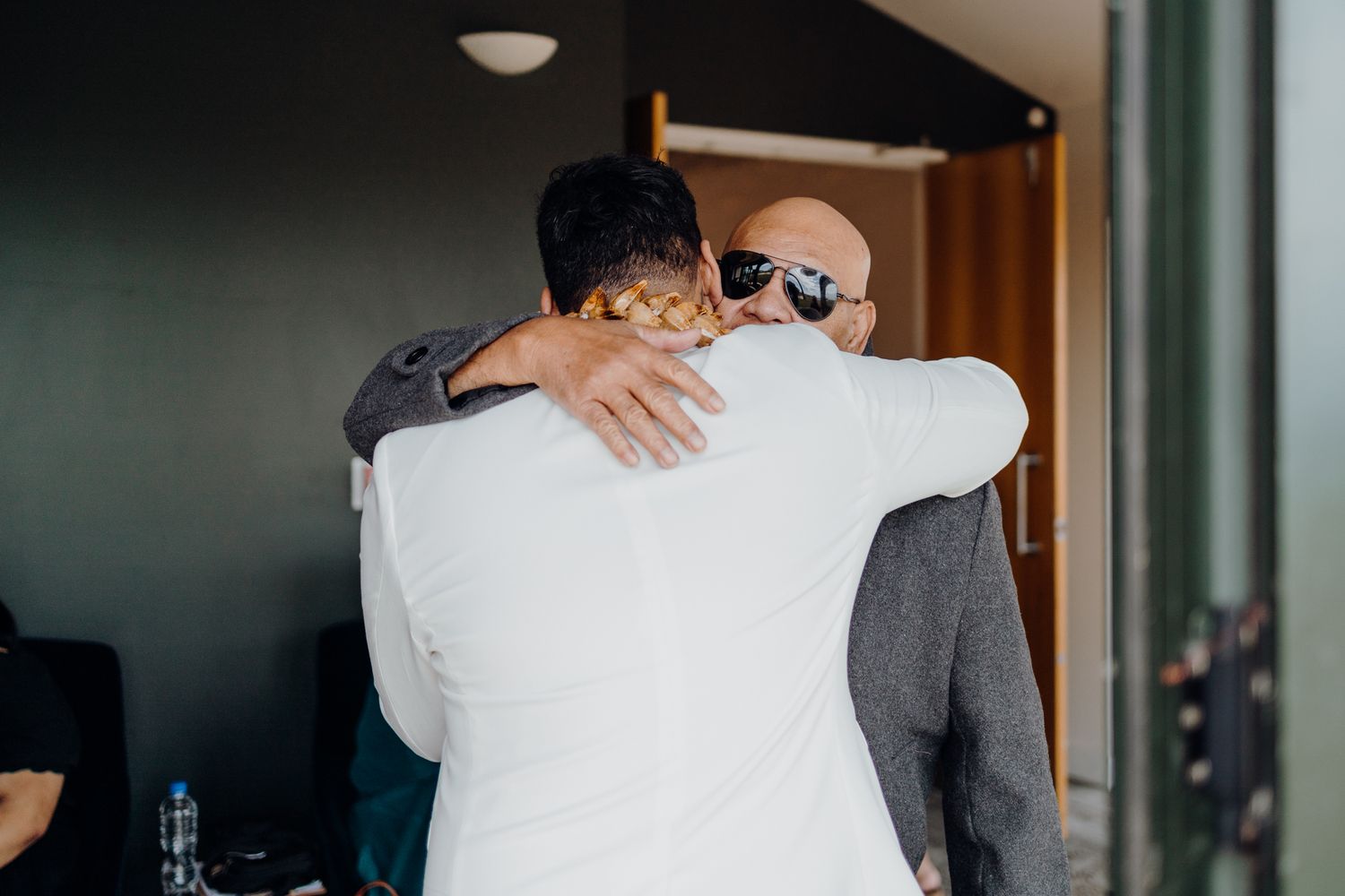 Two people sharing an emotional embrace at an indoor venue.