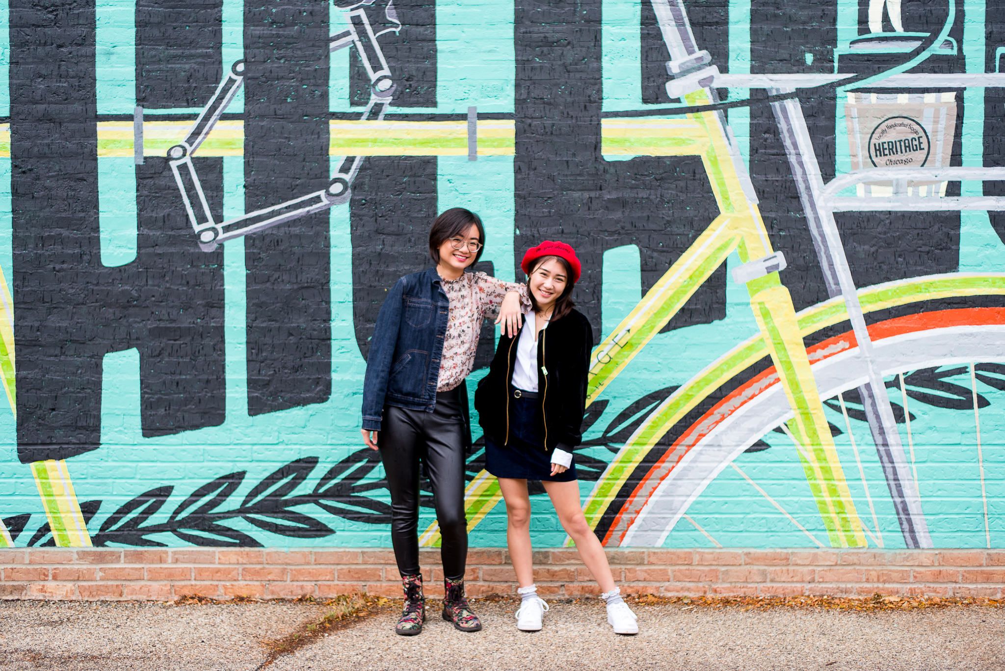 twin sisters in front of mural wall for chicago senior pictures
