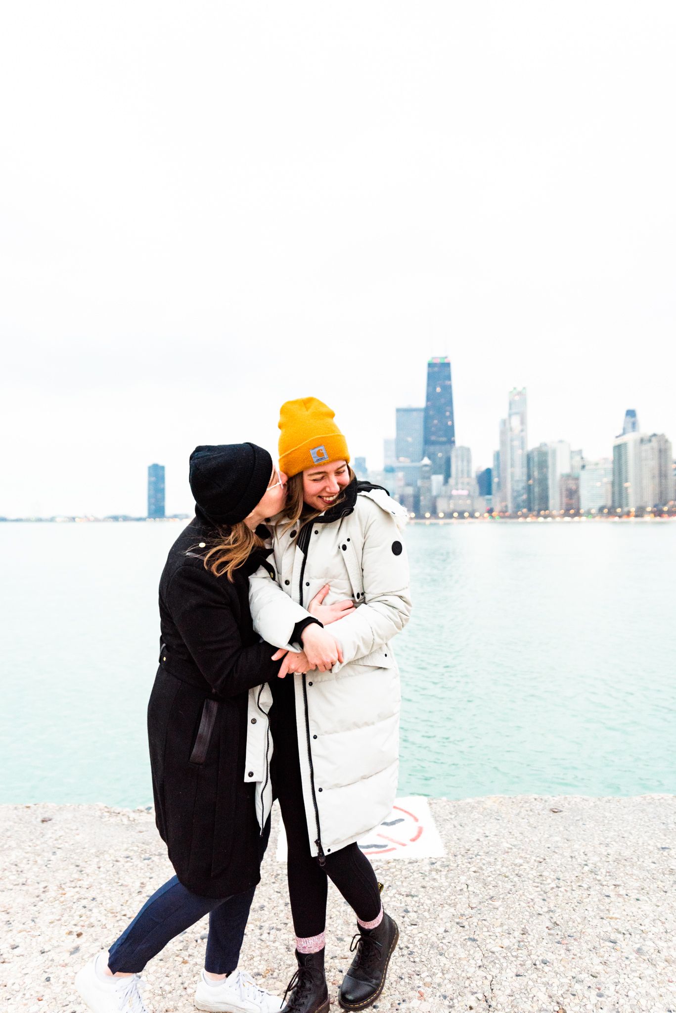 two women on pier at North Avenue Beach hugging and laughing