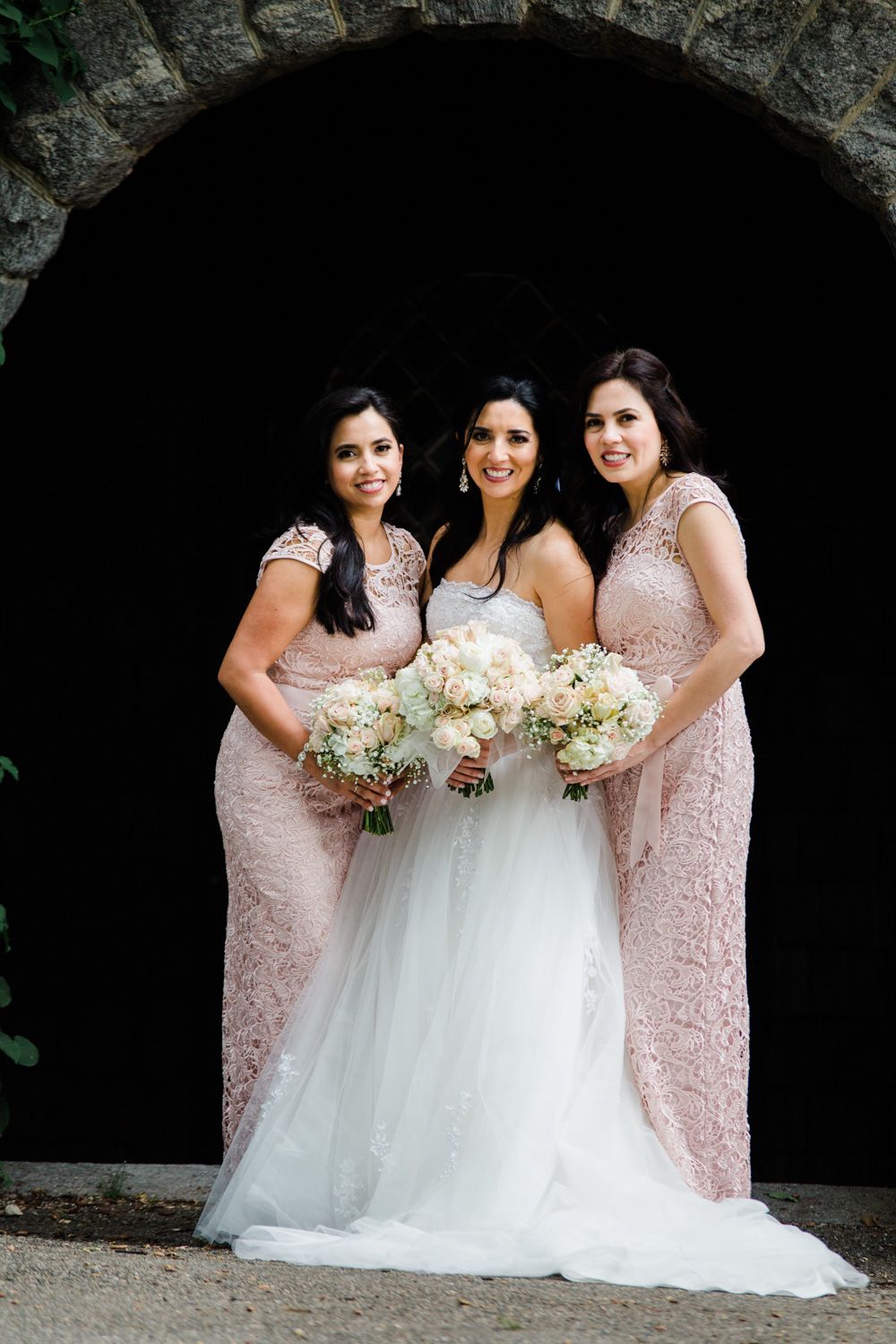 Bride in tulle dress and bridesmaids wearing blush lace