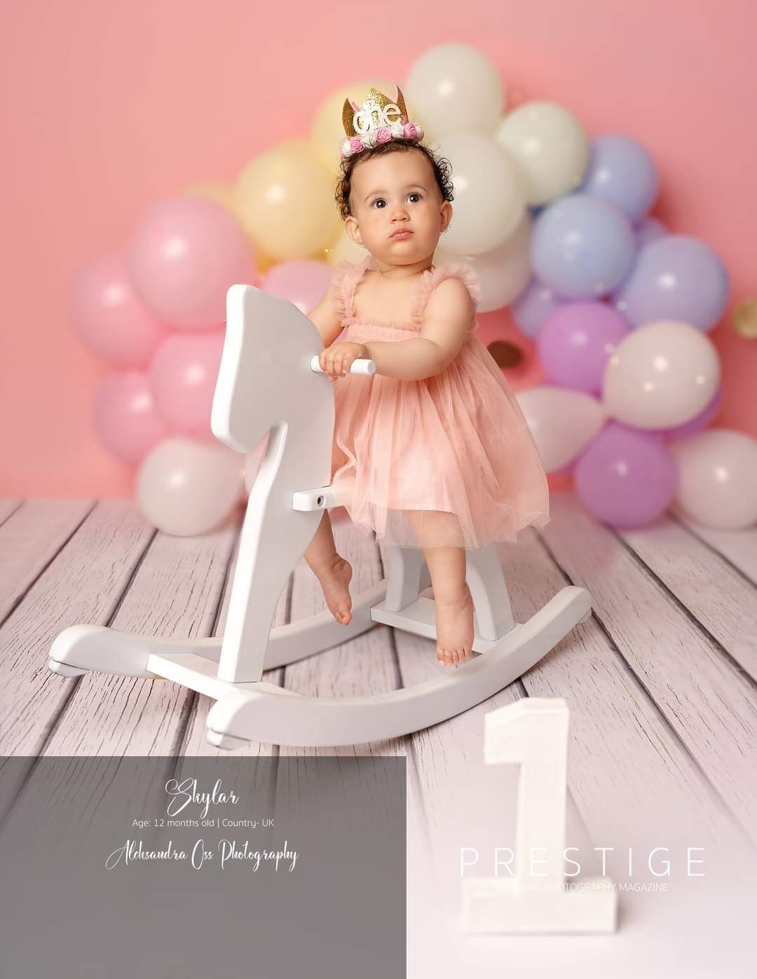 Baby on rocking horse during birthday session in studio
