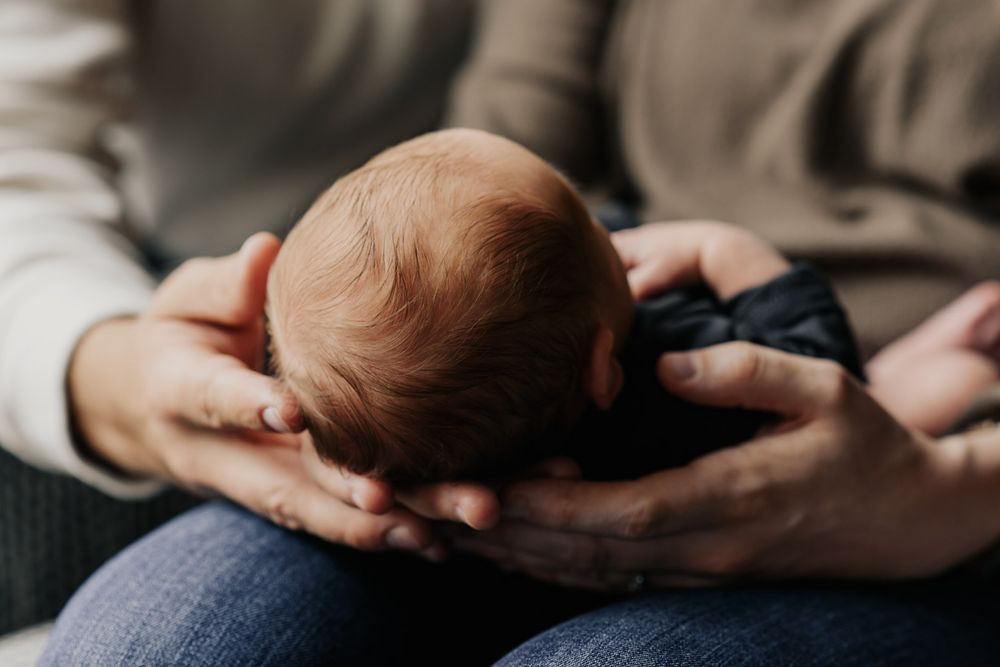 Vanourny Newborn Session Lifestyle Photography Mom and Dad holding newborn baby in lap