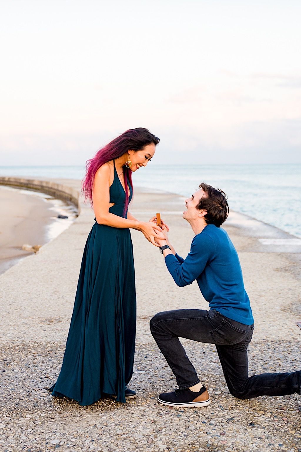 man on one knee holding hands and ring of his new fiancee on North Avenue beach