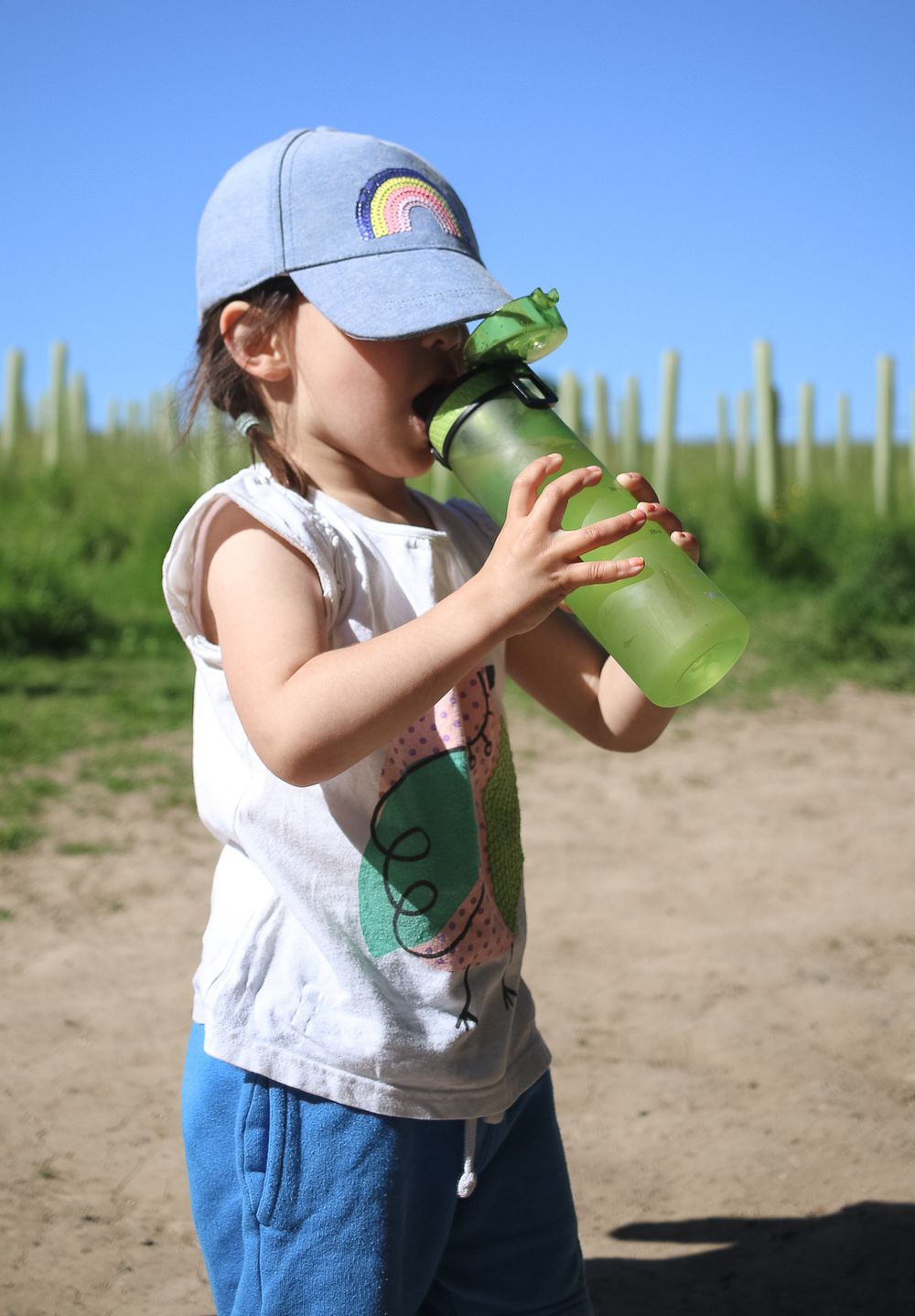 Drinking water on warm day during outdoor family session in Barnet, Hertfordshire