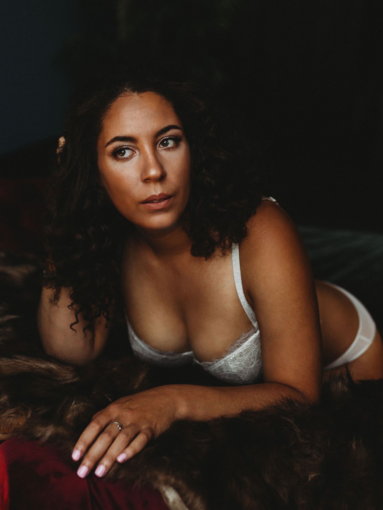 Intimate portrait in silver lingerie with moody dark lighting.