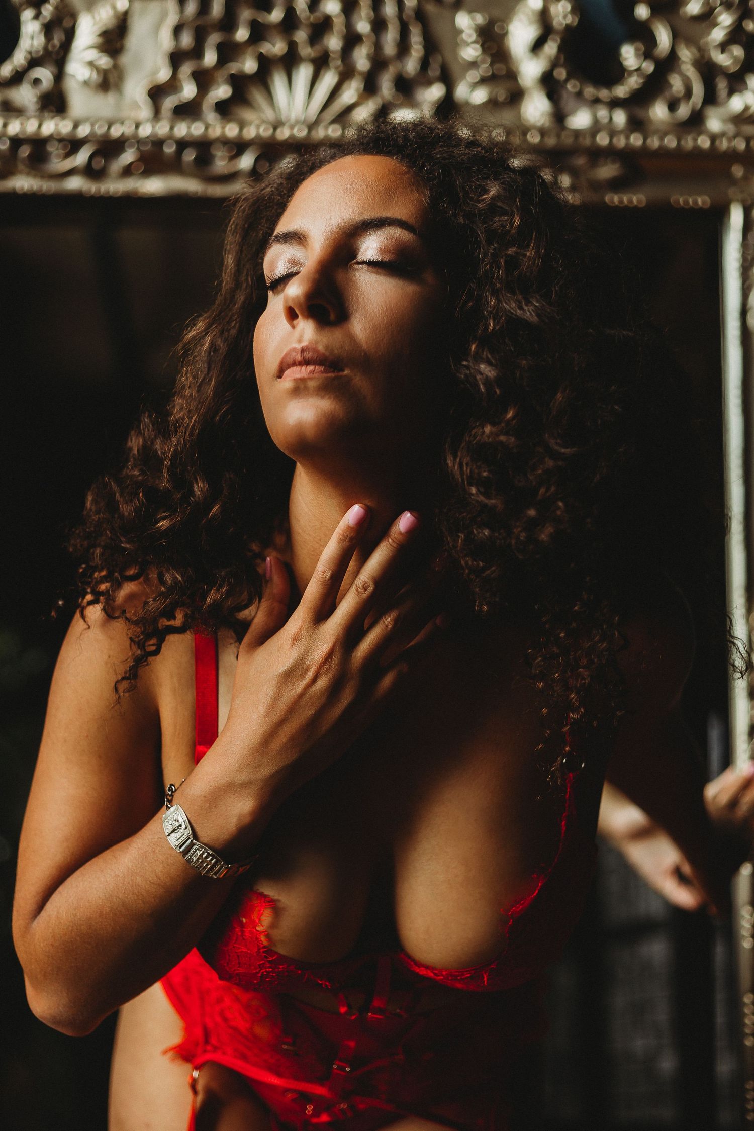Artistic portrait with ornate frame showing curly hair and red lingerie.