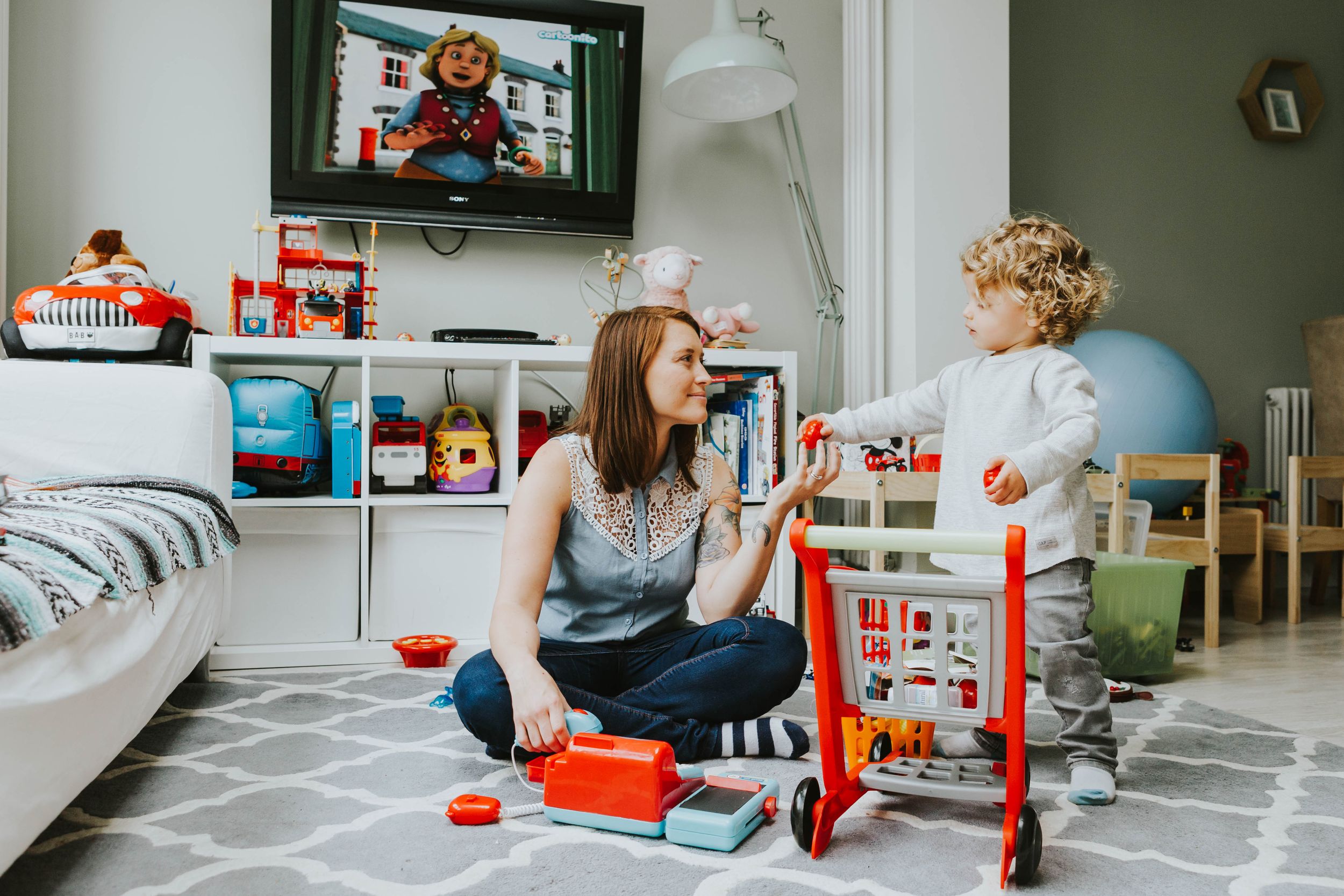 mum and toddler son playing with toys on floor at home in Hornchurch