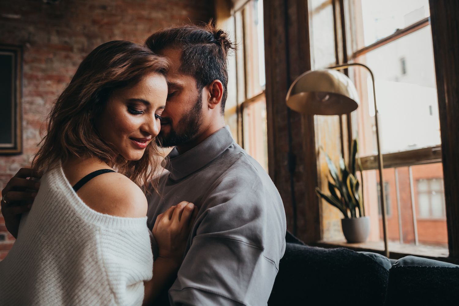man whispers in womans ear romantically at loft in seattle for couples photography, Issaquah WA by Shutterbabe Snaphots