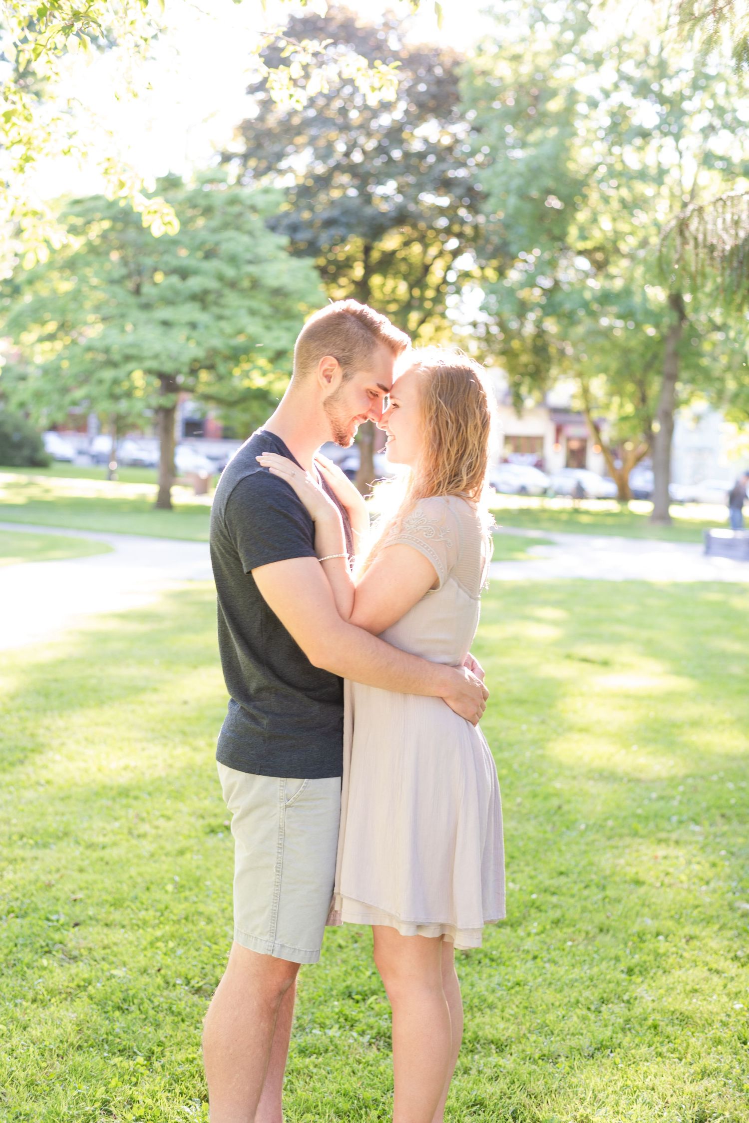 Couple touching foreheads in sunlight in park for engagement in Franklin Pennsylvania