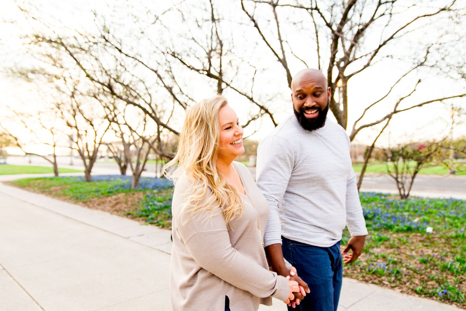 man and woman holding hands laughing in Grant Park sunrise engagement pictures in Chicago