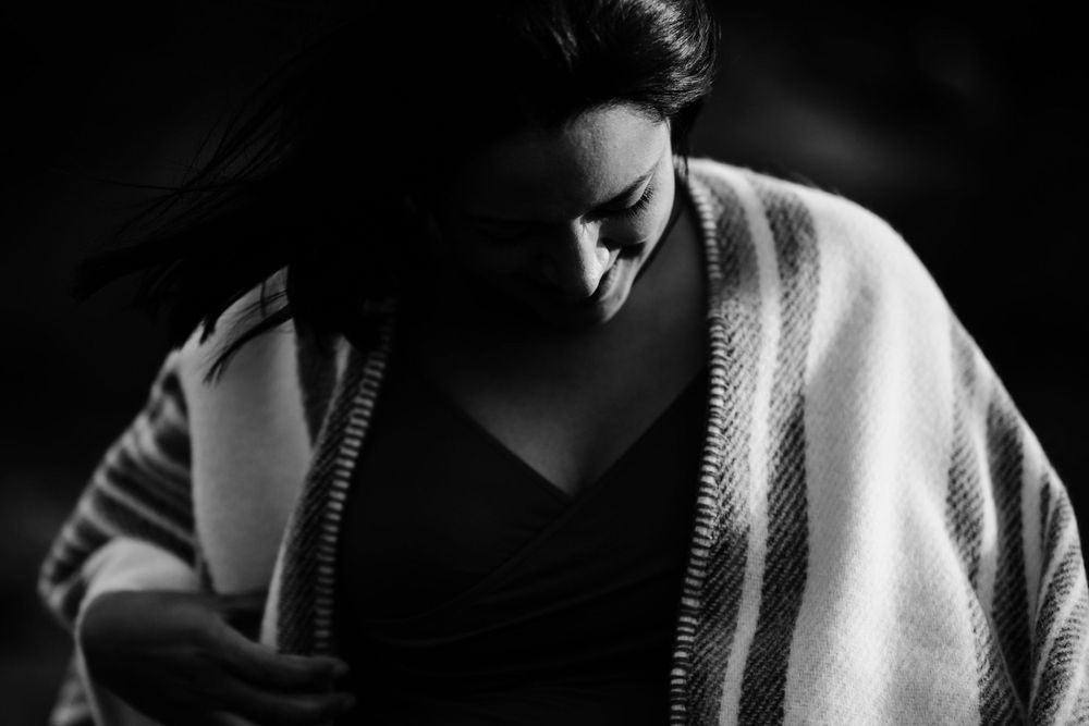 Moody black and white portrait with soft wrap draped around shoulders.