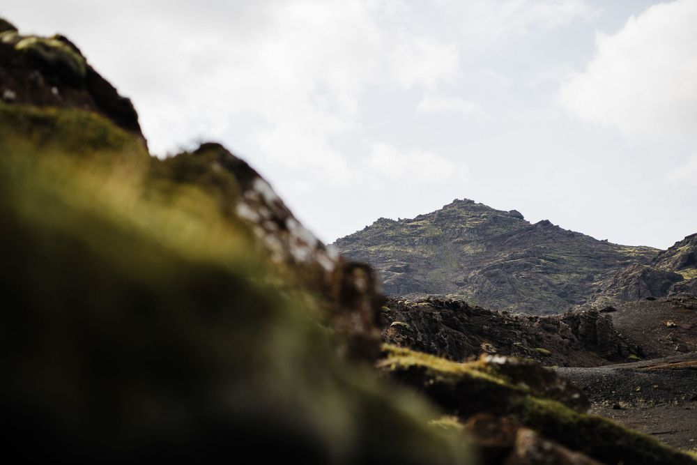 Dramatic mountain landscape with rocky peaks against cloudy sky in soft focus.