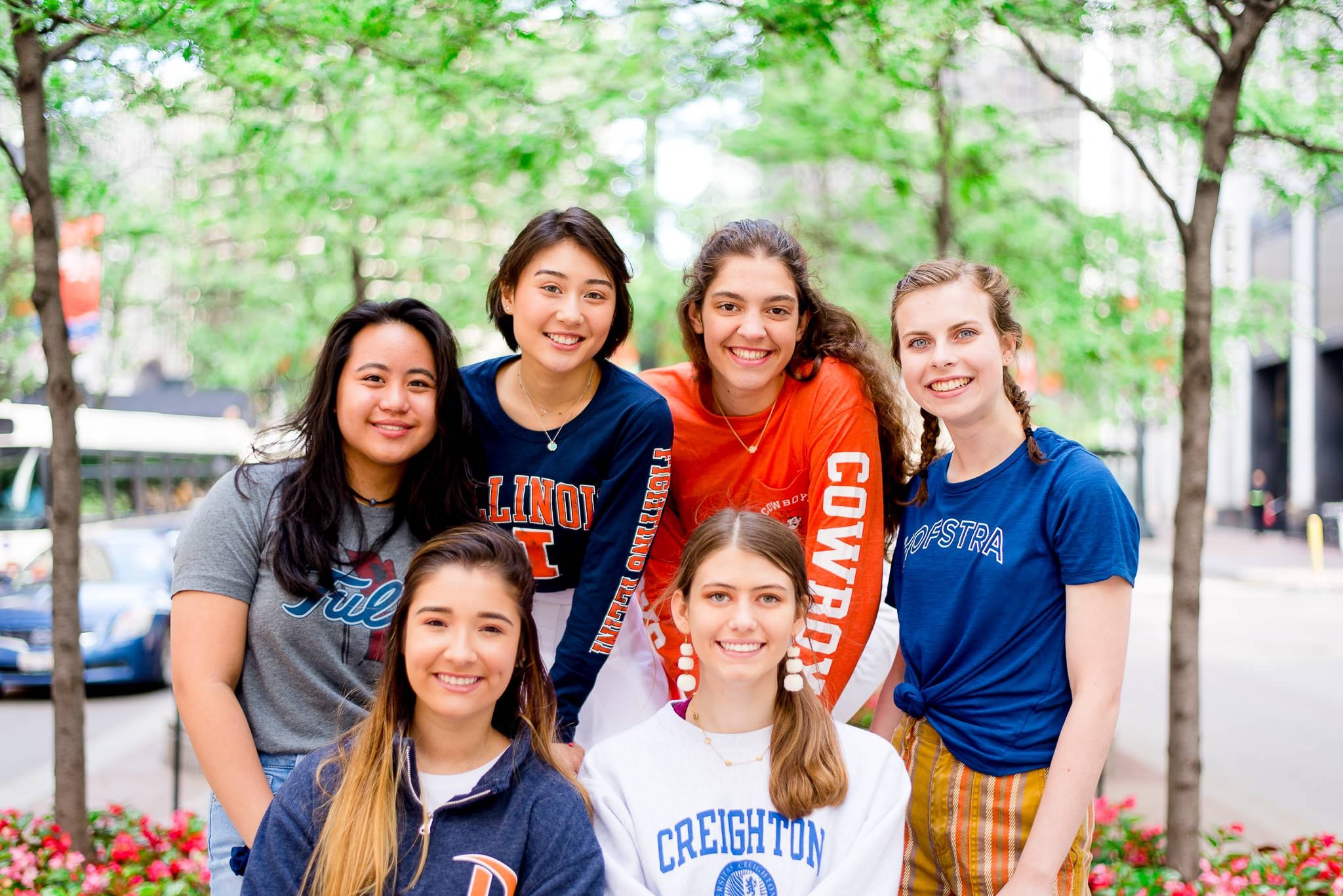 six girls in college t-shirts smiling for Chicago senior pictures in downtown Chicago