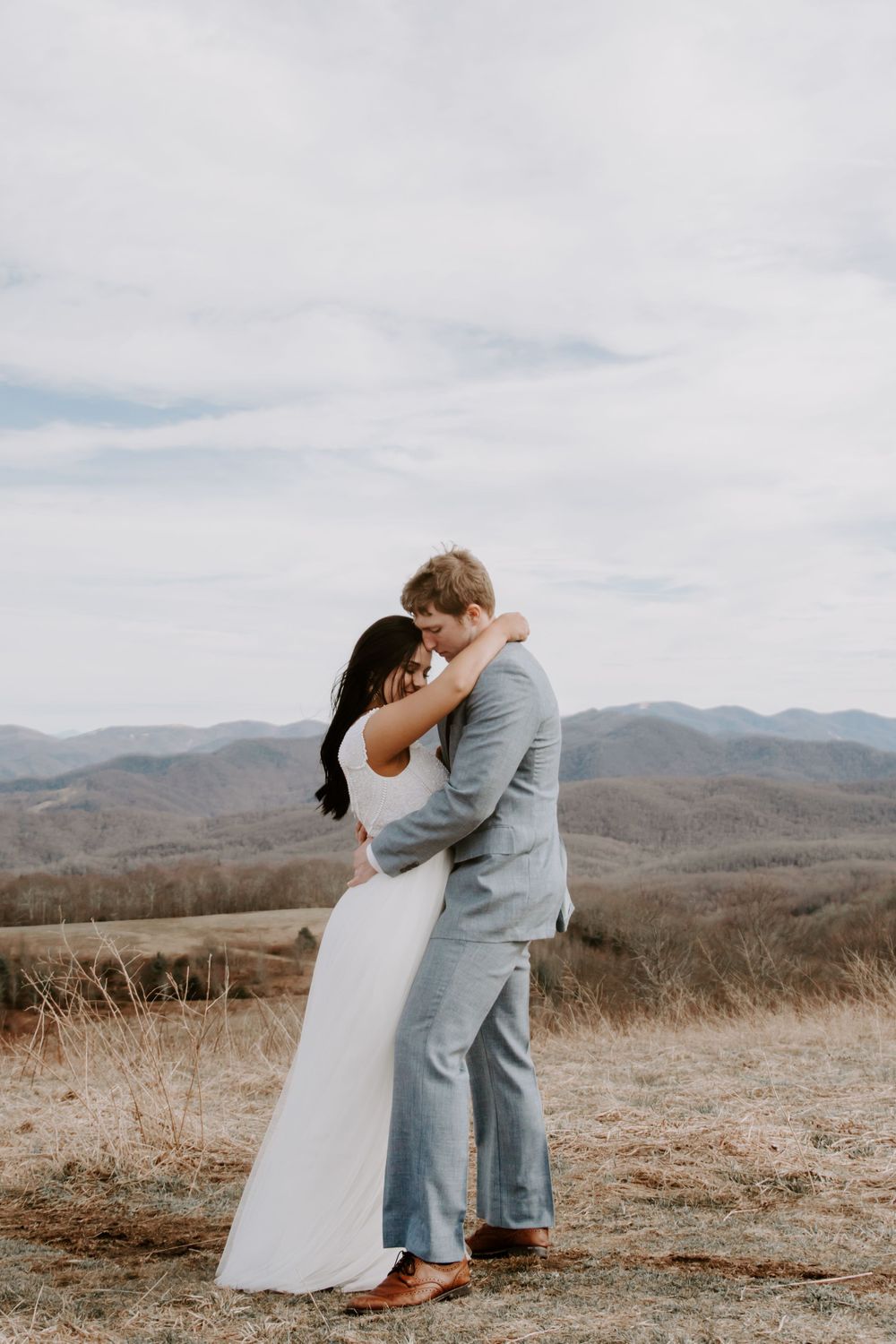 new weds hugging after saying this vows on the side of a mountain in north carolina