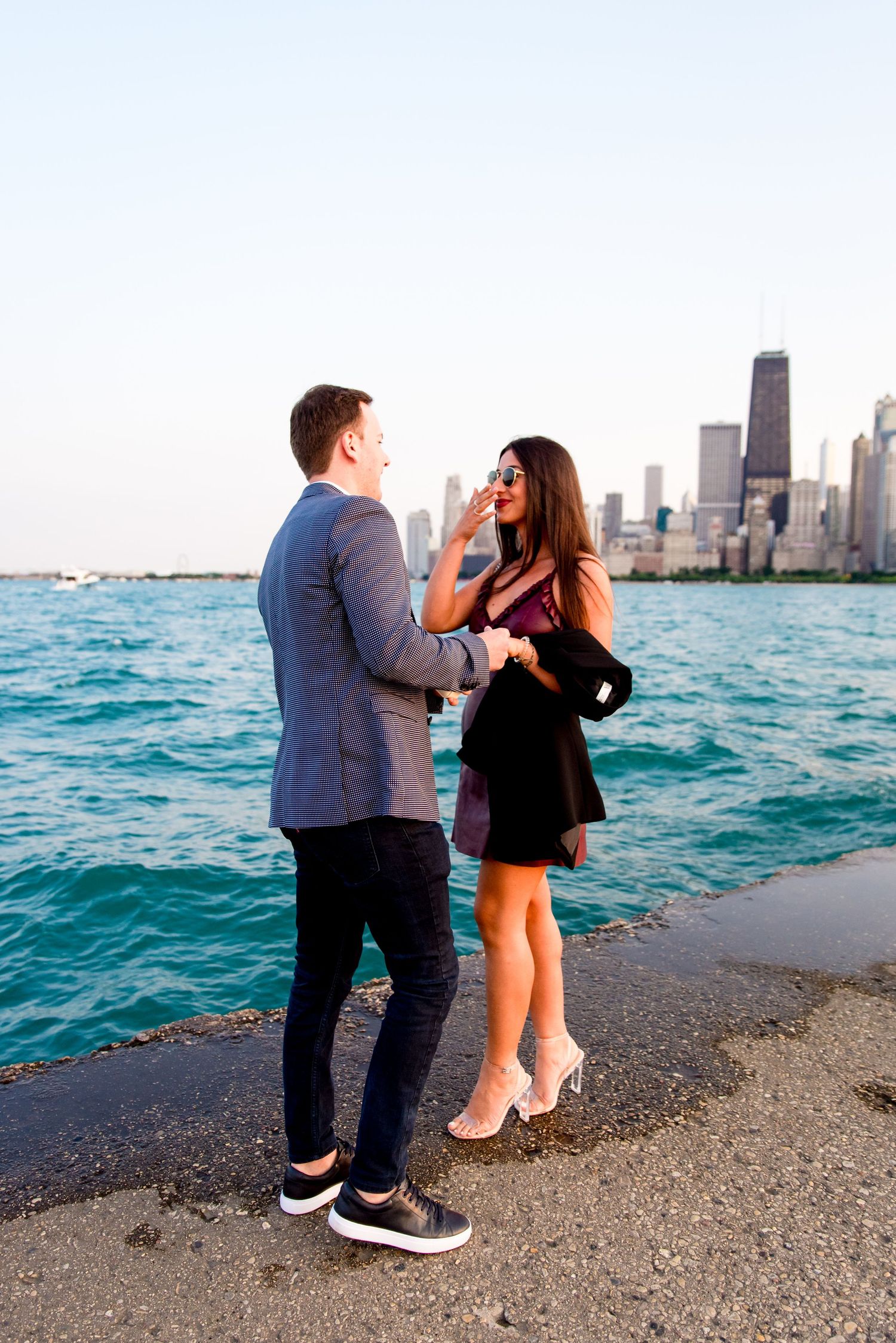 young woman smiling at fiance in front of Chicago skyline after North Avenue Beach proposal