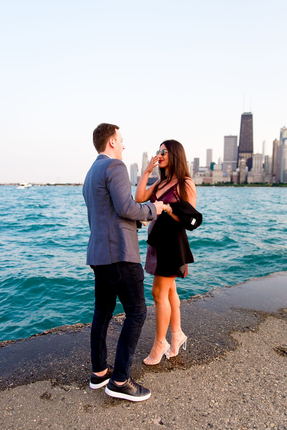 young woman smiling at fiance in front of Chicago skyline after North Avenue Beach proposal