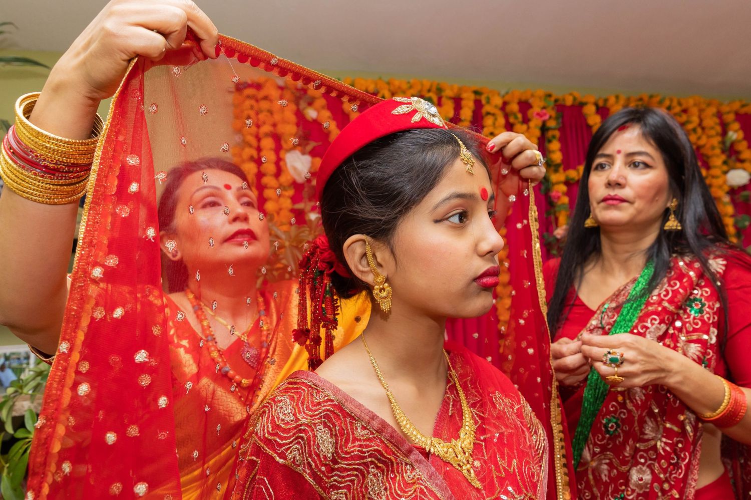 Traditional wedding ceremony with women in colorful saris performing rituals.