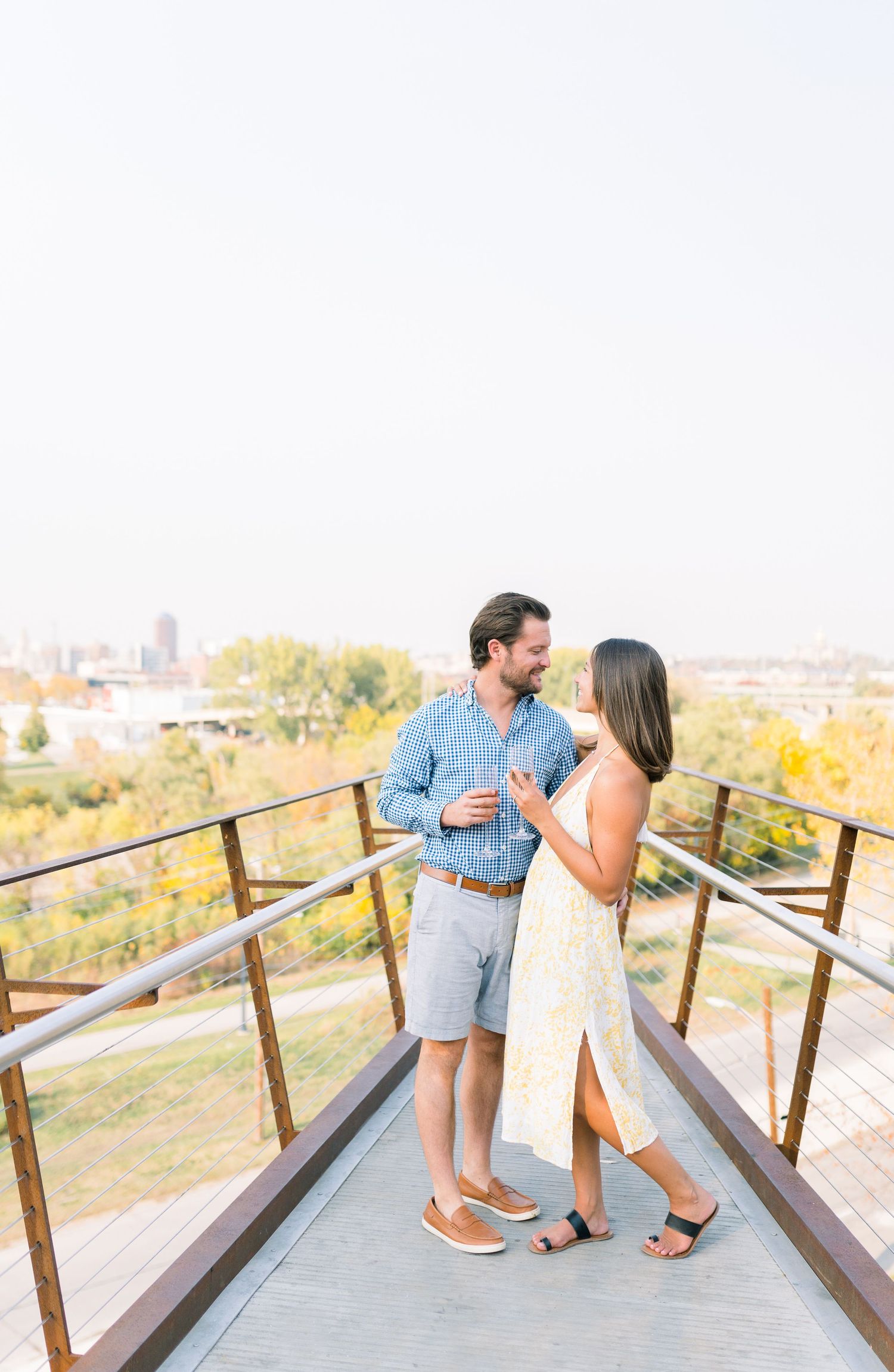 Des Moines Engagement photos with champagne in downtown Des Moines, Iowa with light and airy photographer Nicole Laing
