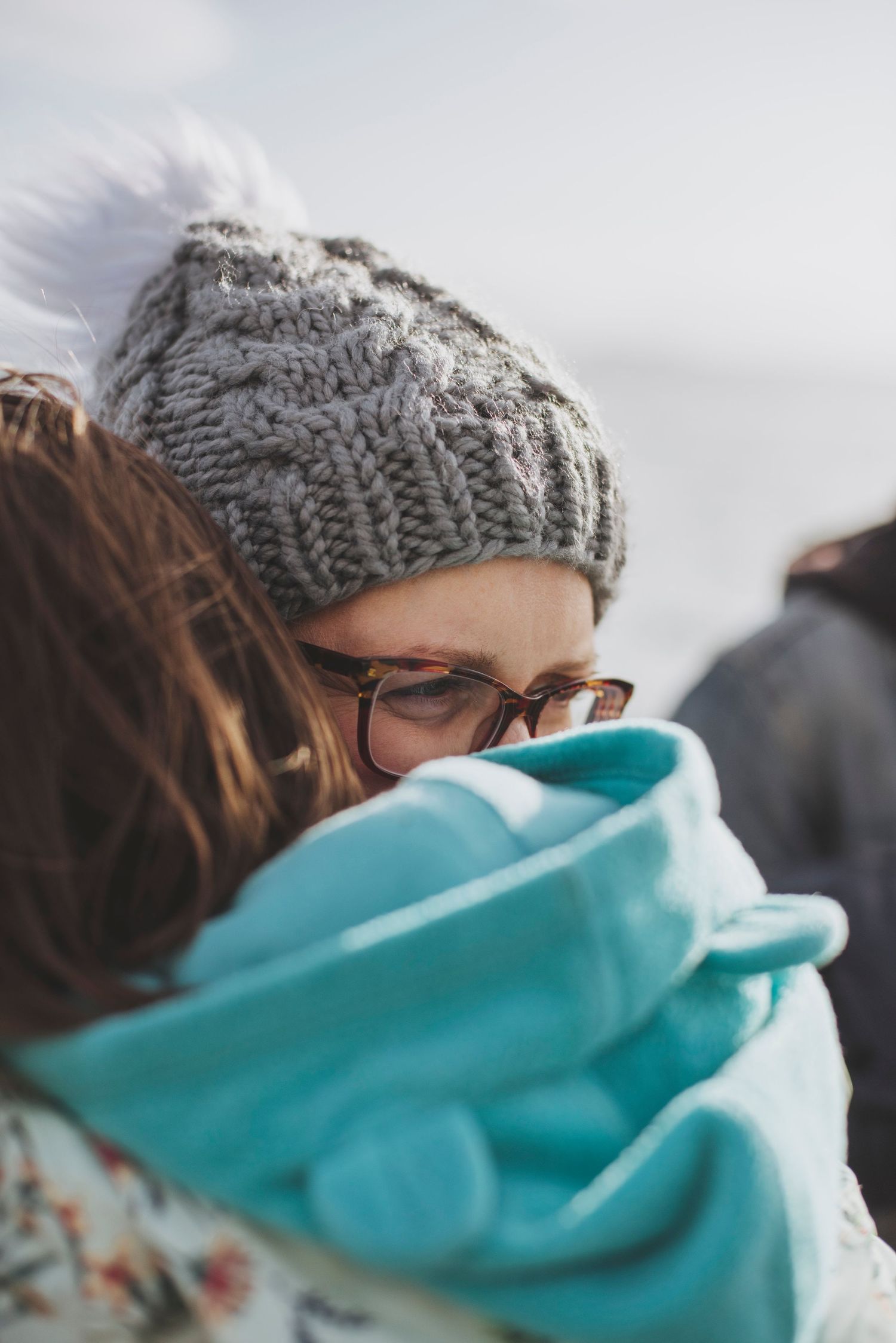 An intimate winter embrace shown with knit hat and turquoise scarf details.