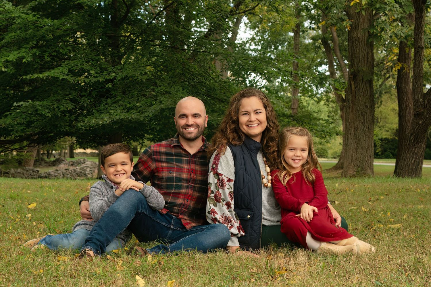 family smiles in posed portrait outdoors