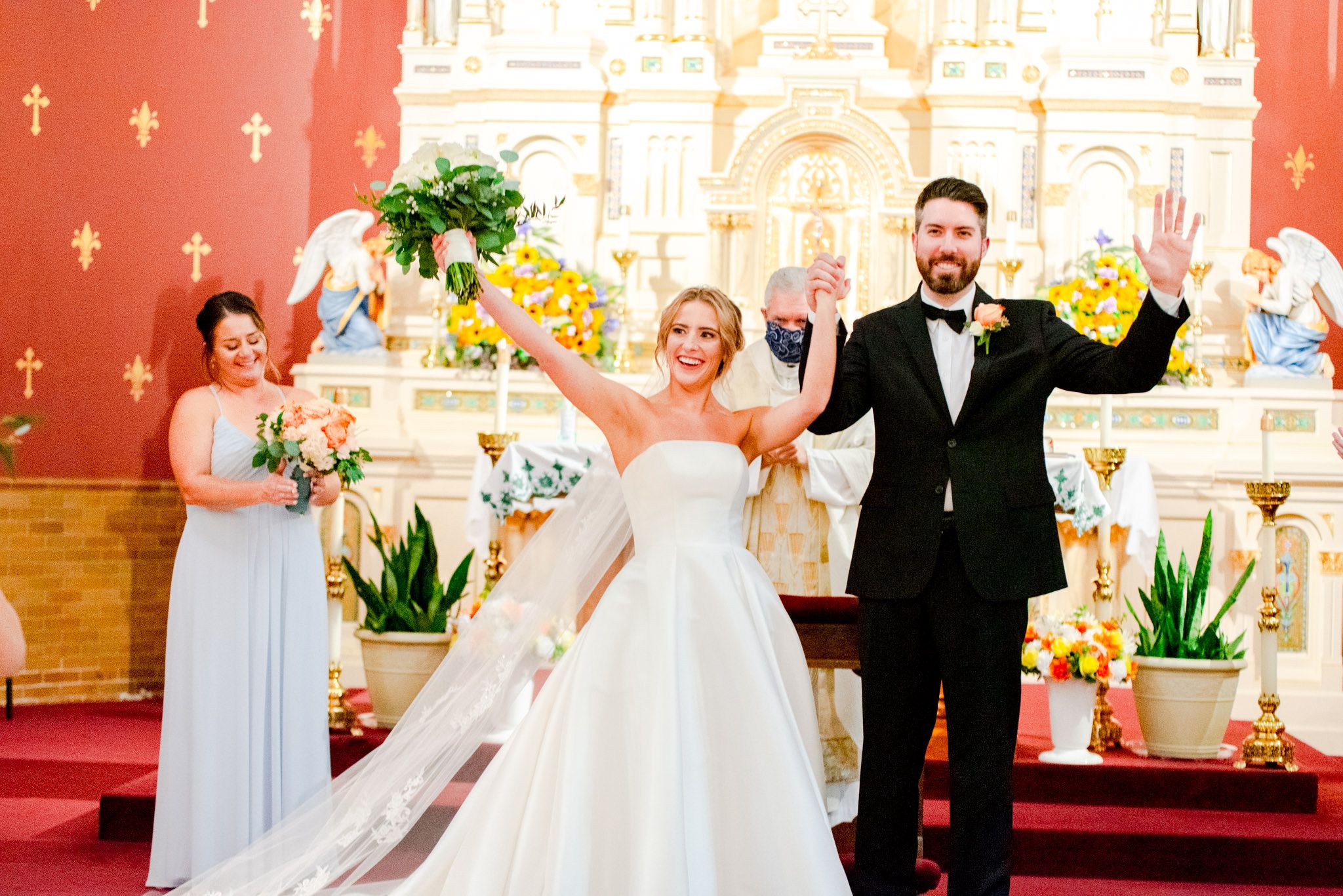 bride and groom holding hands and raising outside hands, celebrating their marriage and walking down the aisle together