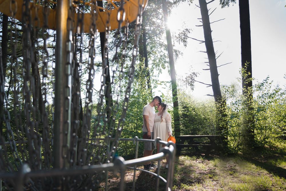 engaged couple smiling and looking at each other disc golf at sweet arrow lake Schuylkill county pa