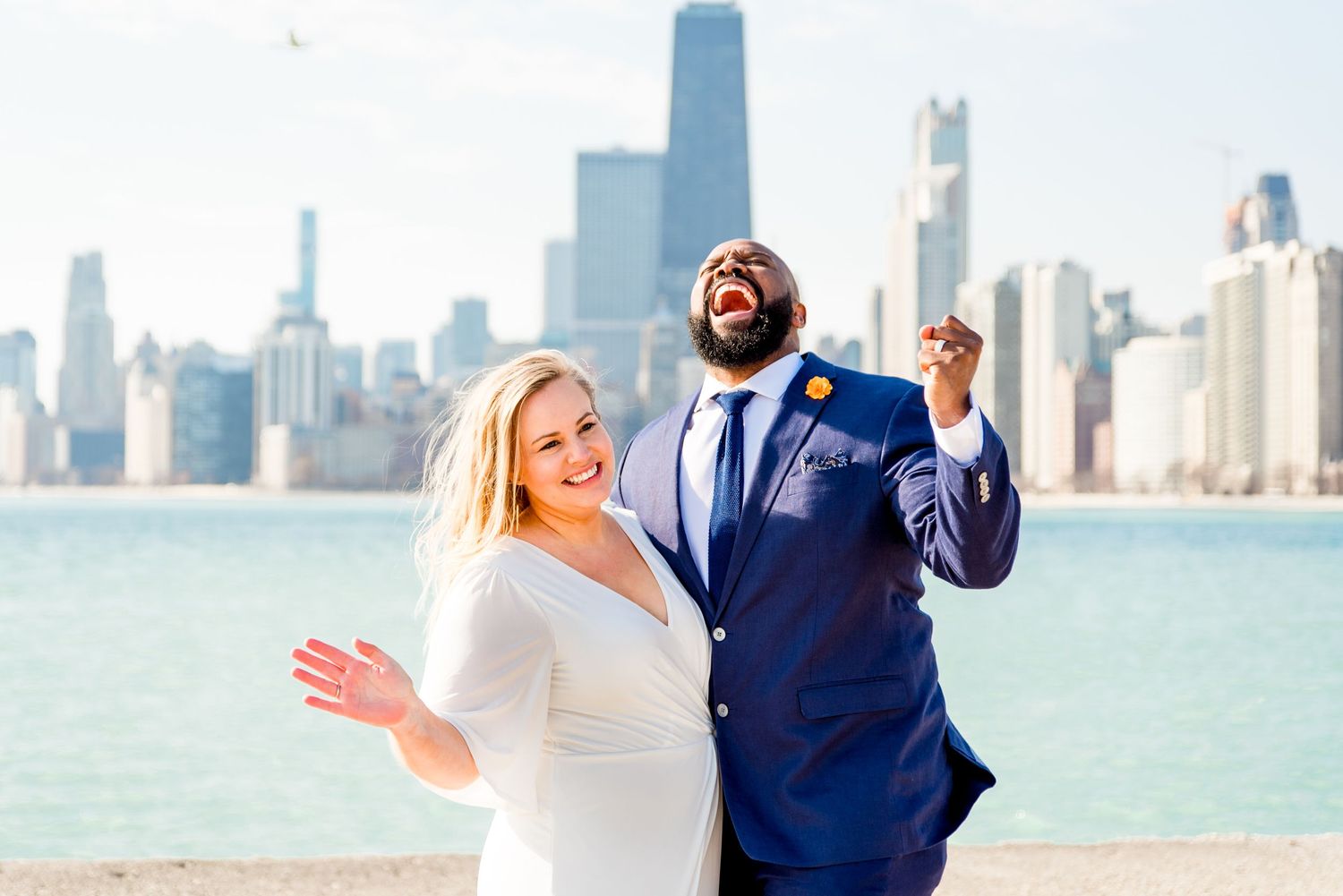 man and woman cheering on pier after north avenue beach elopement in chicago